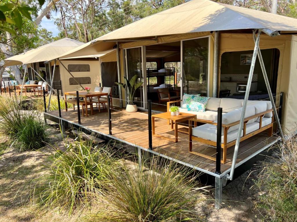 une tente avec un lit et une table. dans l'établissement Noosa North Shore Retreat, à Noosa North Shore