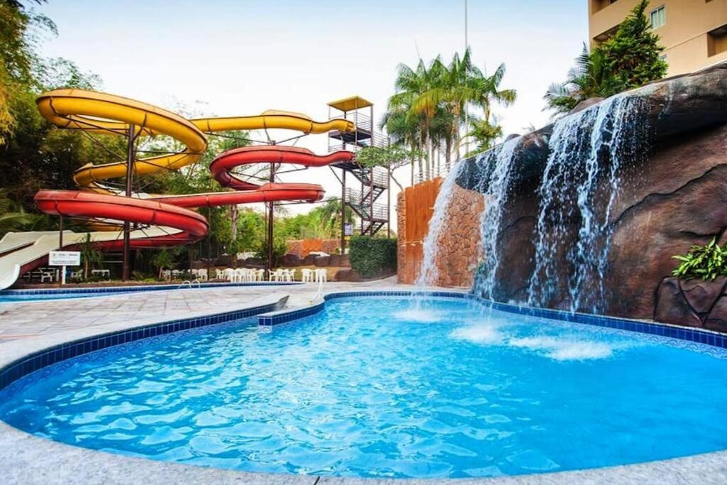 um escorrega aquático numa piscina com cascata em Golden Dolphin GRAND HOTEL - Apartamento COM VISTA em Caldas Novas