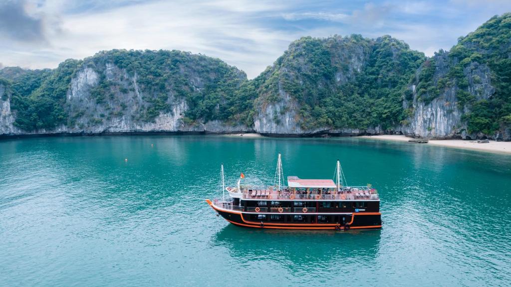 um barco em um corpo de água com falésias calcárias em Daiichi Boutique Cruise em Ilha de Cát Bà