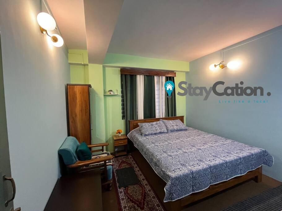 a bedroom with a bed and a sign on the wall at Stay Cation “live like a local” in Gangtok