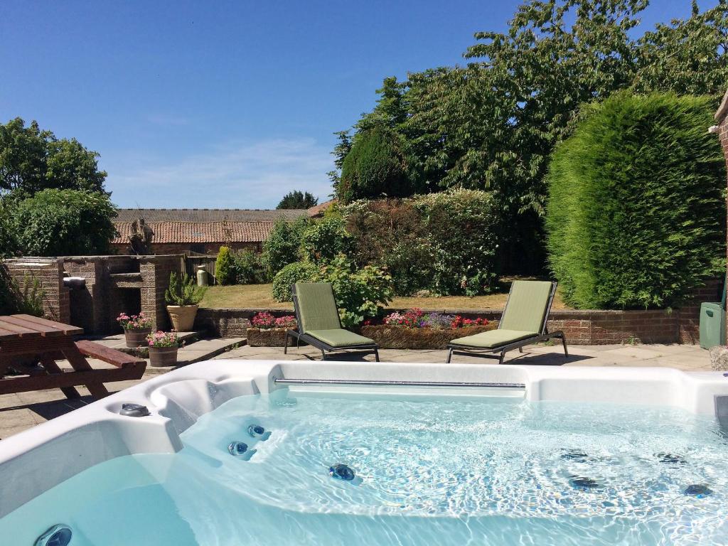 a hot tub in a yard with two chairs at Carr House in Cayton