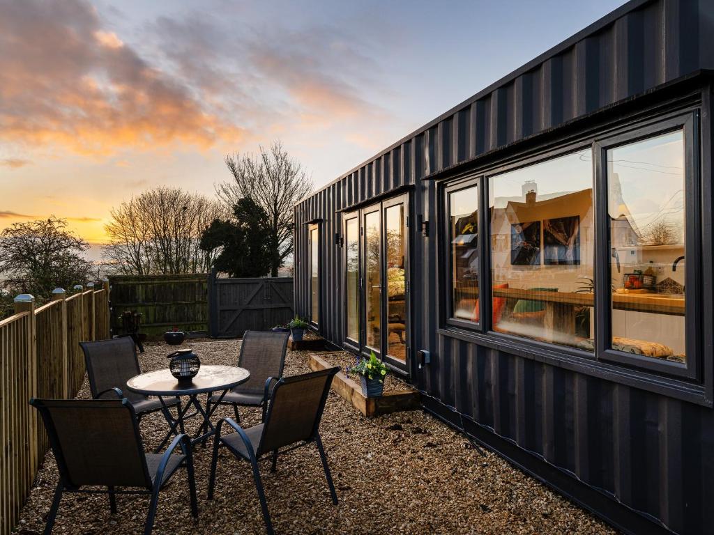 a black tiny house with a table and chairs at Sunrise Cabin in East Ilsley