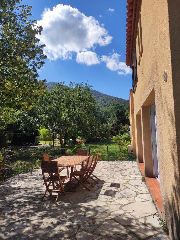 une table et des chaises installées à côté d'un bâtiment dans l'établissement Maison pour séjour en famille, à Montesquieu