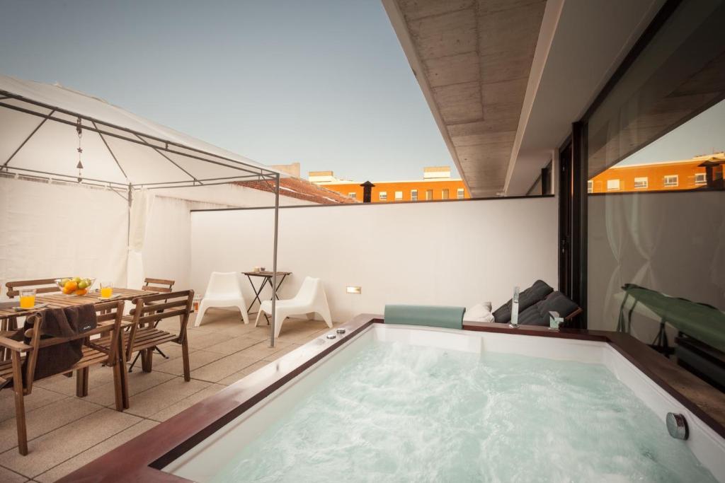 a swimming pool in the middle of a living room with a table and a dining at Urban Master in Aveiro