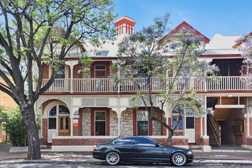 um carro preto estacionado em frente a uma casa em Cecil Mansions Wi-fi Parking Central Location em Adelaide