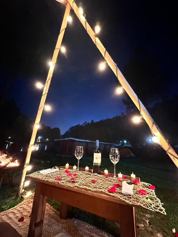 ロス・アスフレスにあるLos Azufres Spa Naturalのワイングラスと夜間の照明付きテーブル