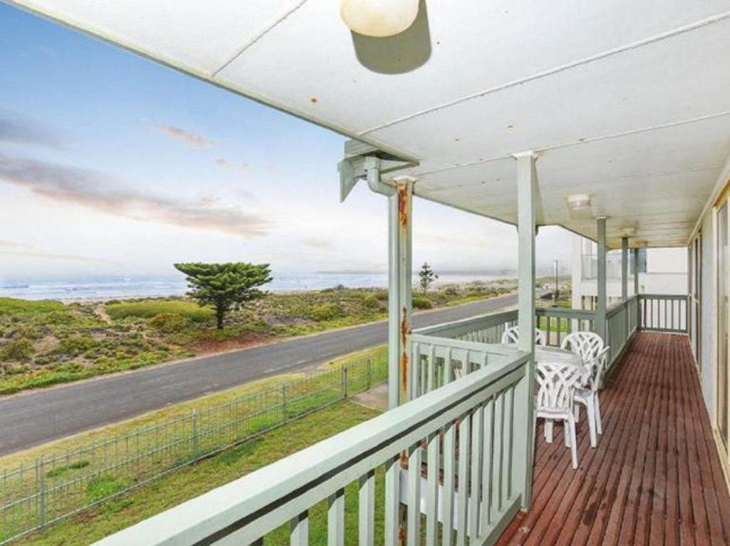 a porch with white chairs and a road at Tahren Beachfront Shack Wifi - Pet-friendly in Middleton
