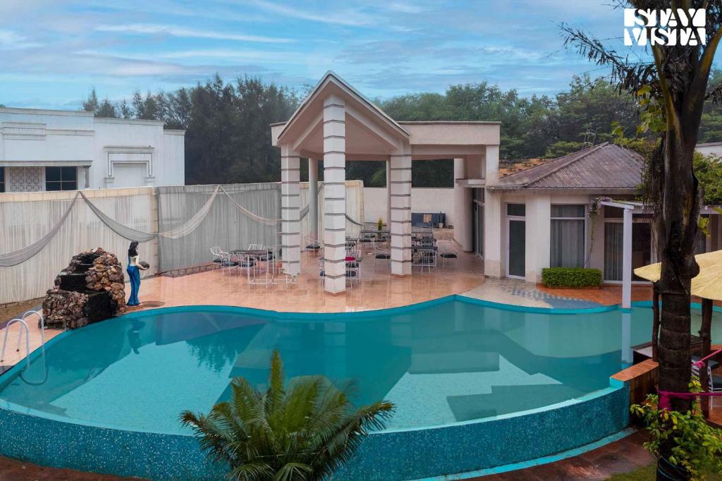 a swimming pool in the backyard of a house at StayVista's Casba Farm Retreat - Pet-Friendly Villa with Rooftop Lounge, Outdoor Pool, Lawn & Bar in Chandīgarh