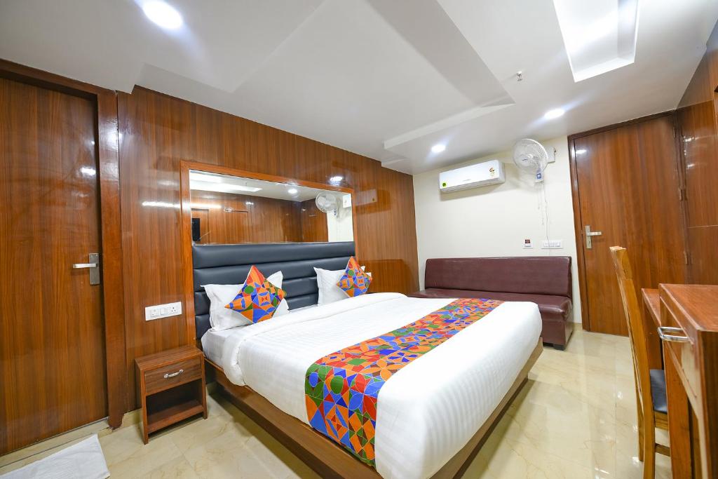 - une chambre avec un grand lit et un mur en bois dans l'établissement FabHotel Mona International, à New Delhi