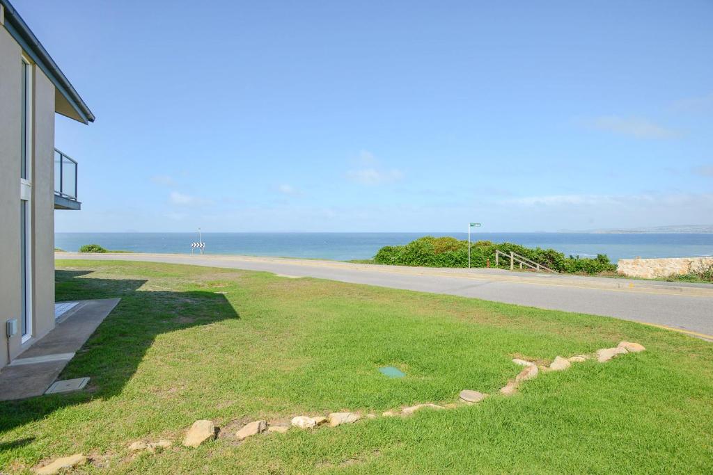 a house with a view of a road and the ocean at South Seas Beachfront Apartments in Port Elliot
