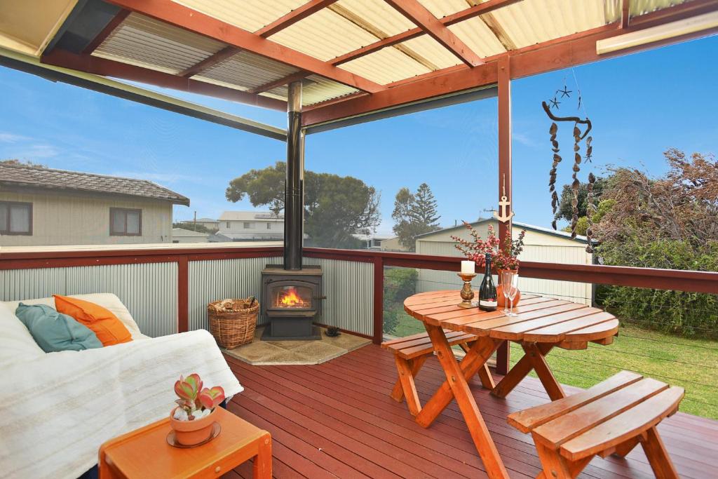 a patio with a table and a fireplace on a deck at Milly's Middleton - Pet-friendly in Middleton