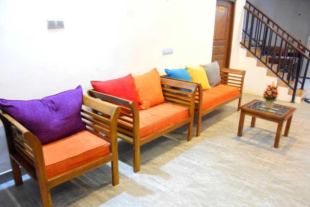 Duas cadeiras com almofadas coloridas sentadas num quarto em blooming hotel em Anuradhapura