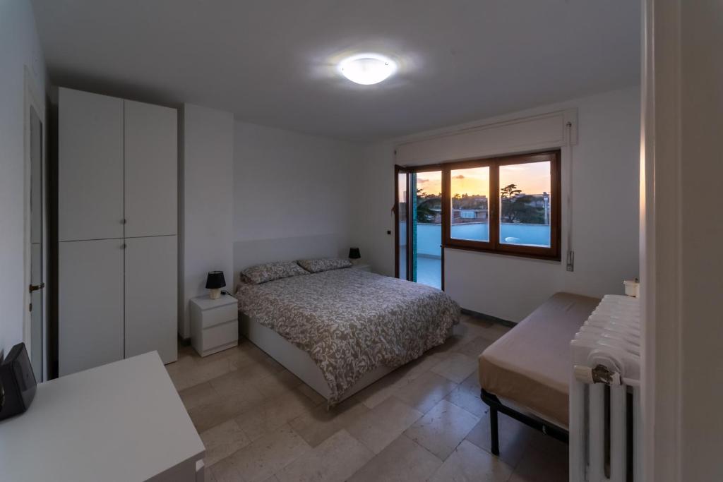 a bedroom with a bed and a large window at Eur - Penthouse in Rome