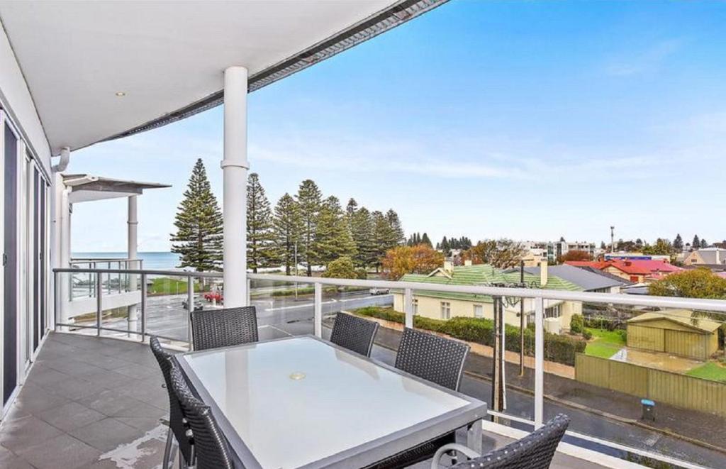 um pátio com uma mesa branca e cadeiras numa varanda em Gallery Resort Style Penthouse No 13 em Victor Harbor