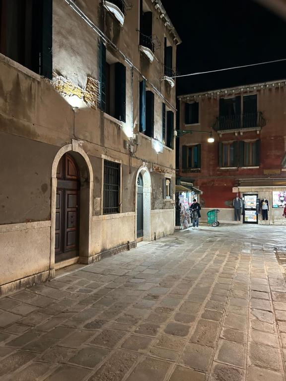 una calle vacía en un viejo edificio por la noche en Lions Venice Guest house en Venecia