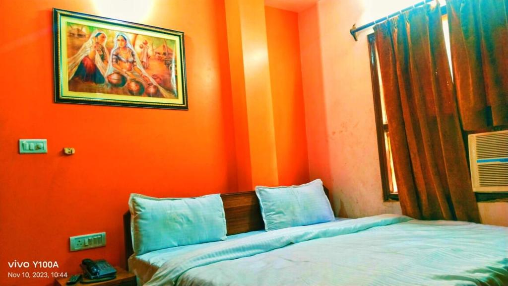 a bedroom with an orange wall with a bed at HOTEL GREEN PALACE in New Delhi