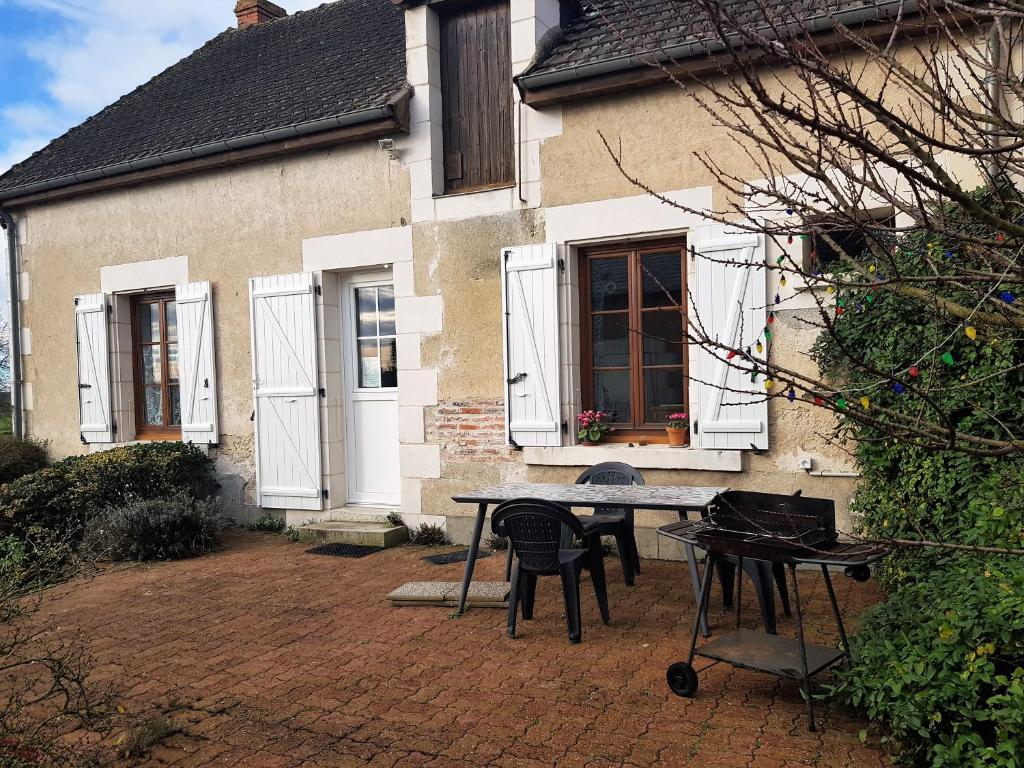 una casa con una mesa y sillas frente a ella en Gite Anne-Marie Davaillon, en Châtillon-sur-Indre