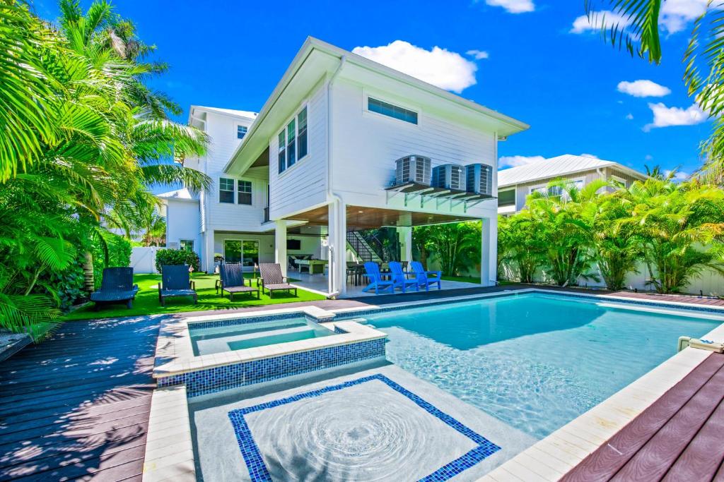 a villa with a swimming pool and a house at Blue Marlin in Anna Maria