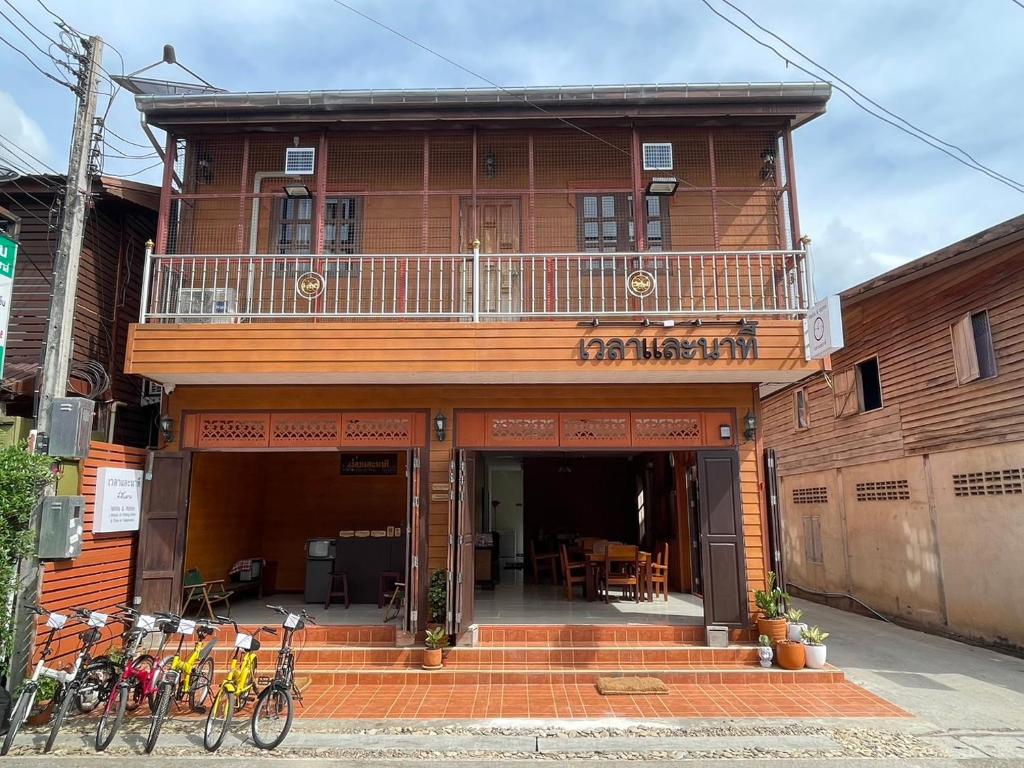 a building with a balcony with bikes parked outside at เวลาและนาที Wella&Natee in Chiang Khan