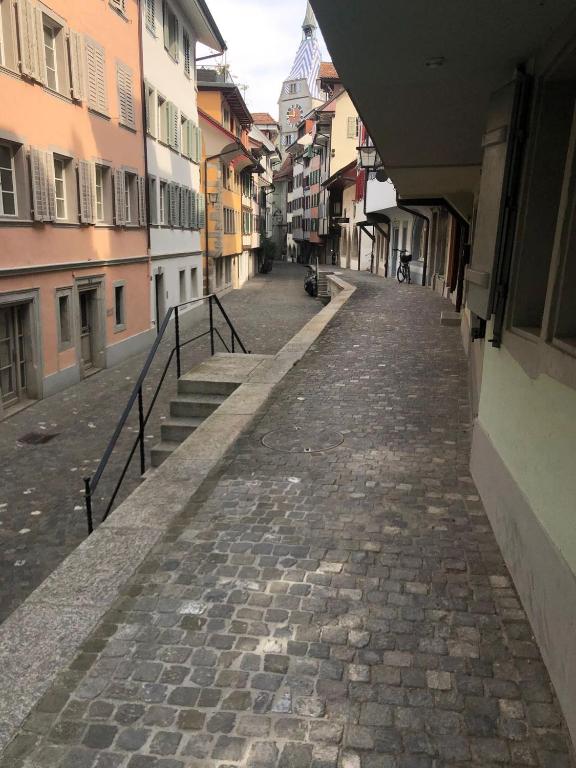 uma rua de calçada numa cidade com edifícios em Bedroom cum office with shared shower in Zug's Old Town em Zug