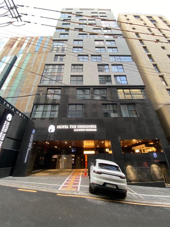 a white car parked in front of a building at HOTEL THE DESIGNERS LYJ SUITE YEOKSAM in Seoul