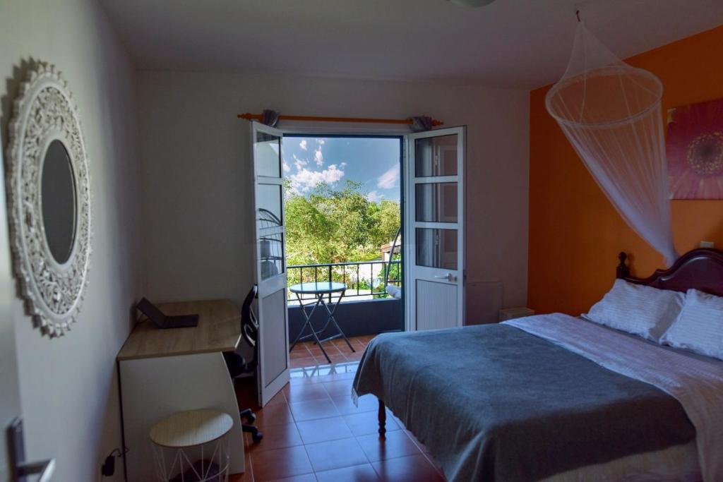 a bedroom with a bed and a door to a balcony at Rita's house in Ponta Delgada