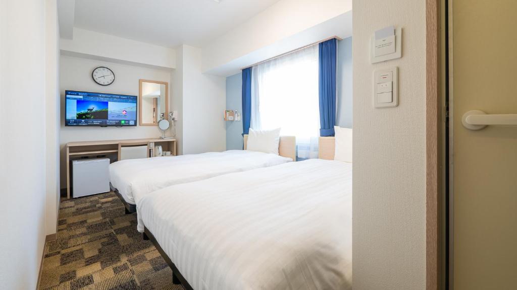 Postel nebo postele na pokoji v ubytování Toyoko Inn Yokohama-eki Nishi-guchi