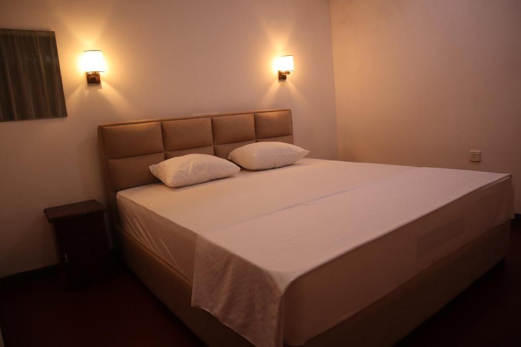 una camera con un letto con due cuscini sopra di Diamond Cottage a Habaraduwa Central