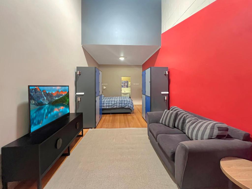 a living room with a couch and a flat screen tv at Port Lincoln Studio Apartments in Port Lincoln