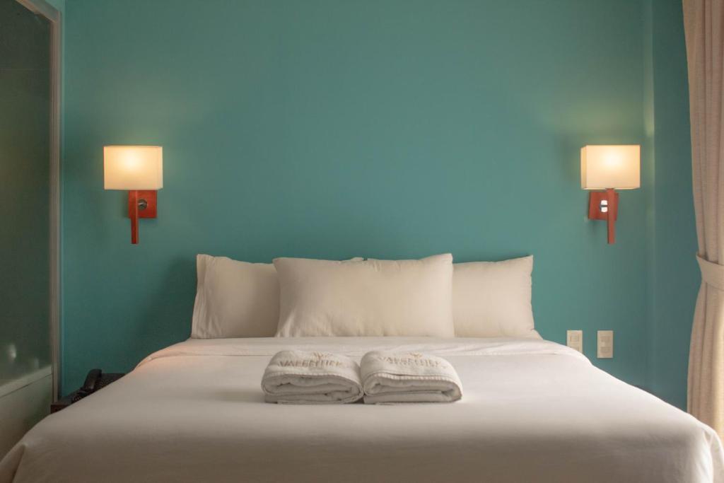 2 Handtücher auf einem Bett mit blauer Wand in der Unterkunft Valentino's Hotel in Angeles