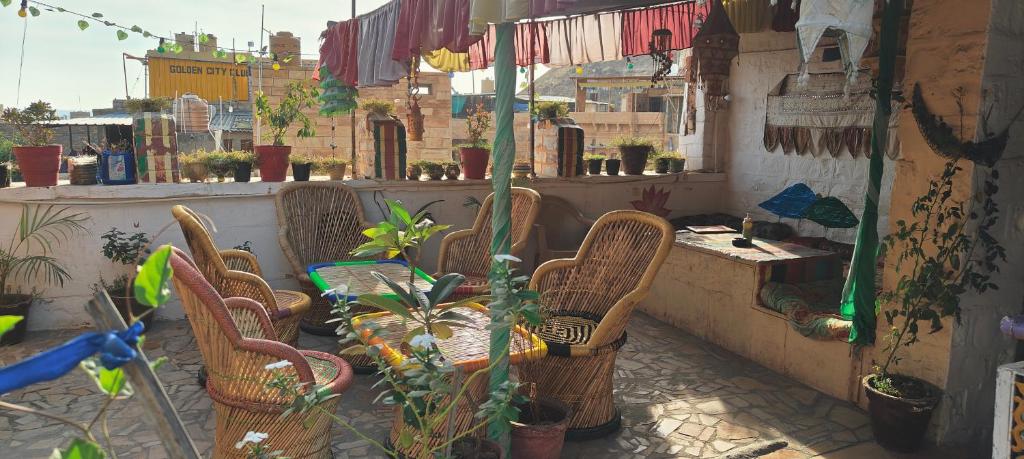 a patio with chairs and a table and plants at Nomadic Backpackers Hostel in Jaisalmer
