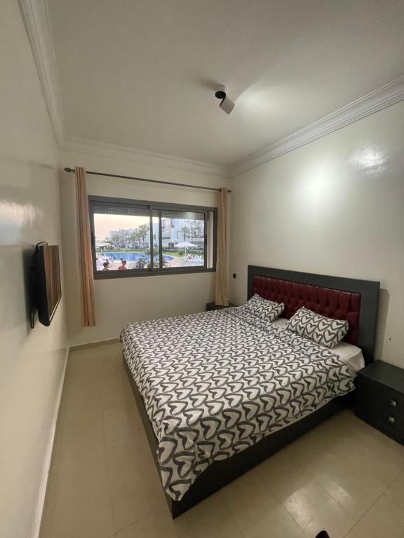 1 dormitorio con cama y ventana en Blanca Beach, en Sidi Rahal