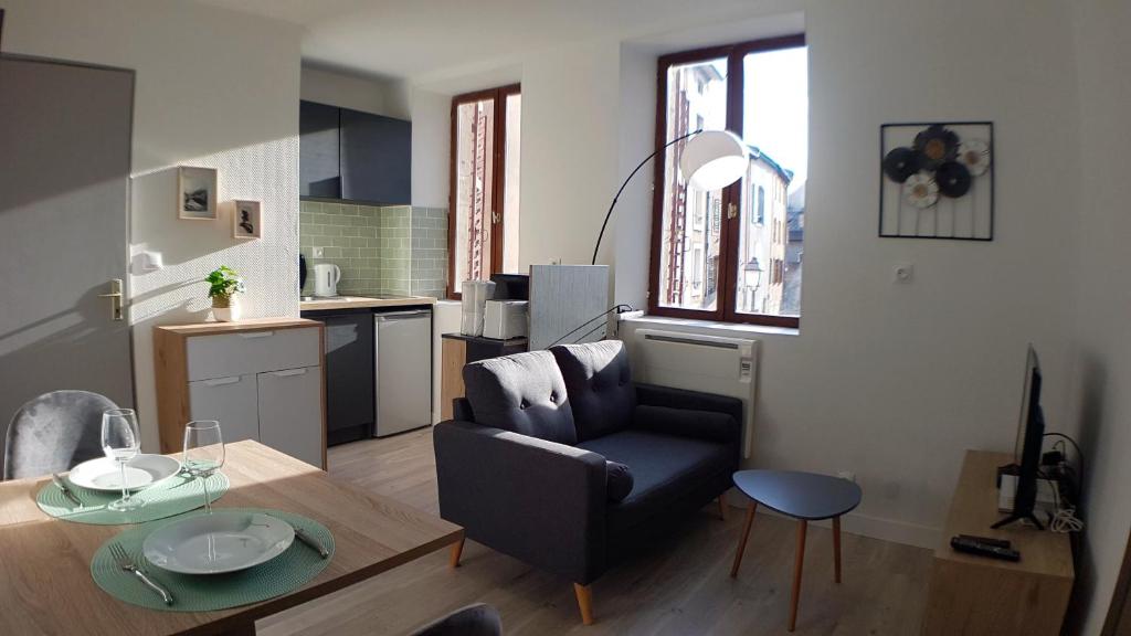 uma sala de estar com uma cadeira e uma mesa em Les Studio Cosy - Lunéville centre em Lunéville