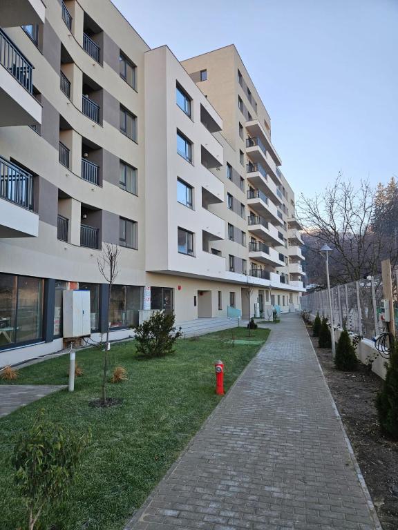 un edificio de apartamentos con una boca de incendios roja en una acera en Garsoniera Gabrielle, en Brasov