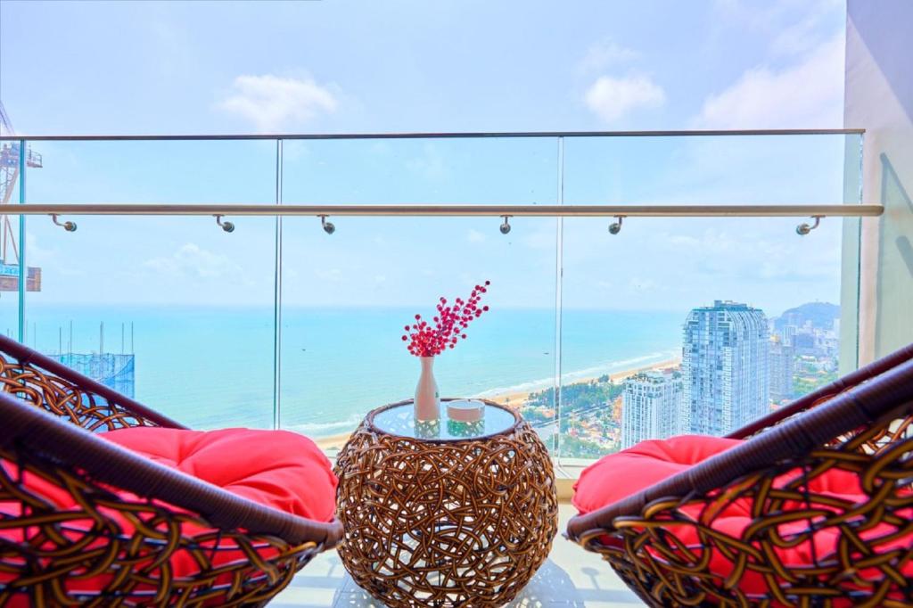 a room with two chairs and a vase on a table at The Sóng Vũng Tàu Căn Hộ Nghỉ Dưỡng Cao Cấp Ven Biển in Vung Tau