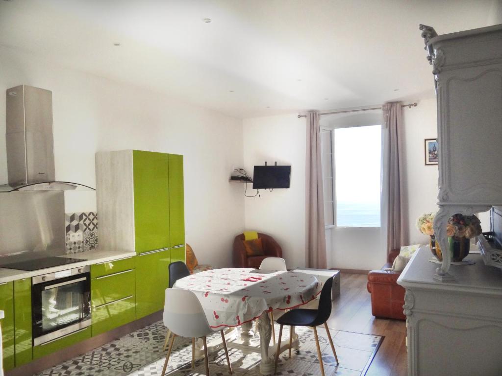 cocina con mesa y armario verde en T3 colonella, en Bastia