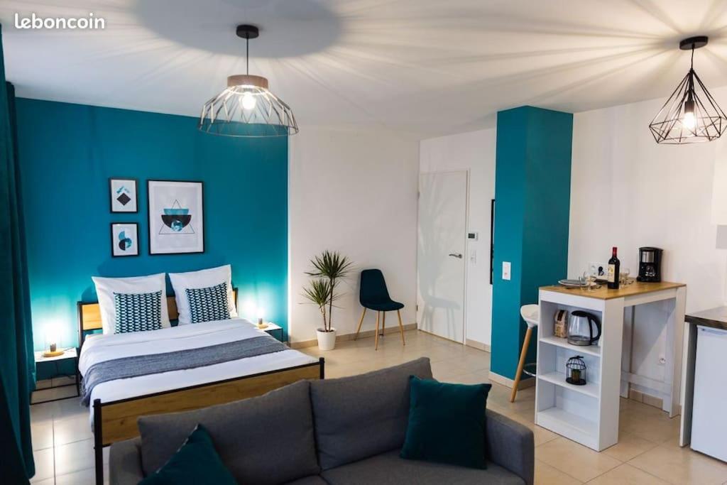 um quarto com uma cama e uma parede azul em Grand studio à 10 min de Disney em Montévrain