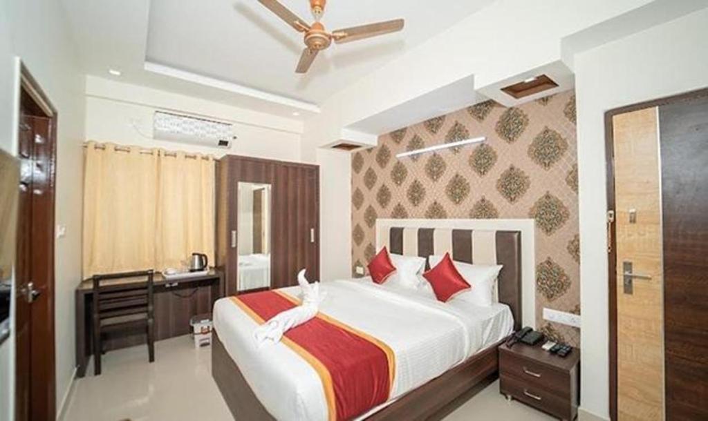 um quarto com uma cama grande e uma secretária. em FabHotel Panchami Comforts em Bangalore