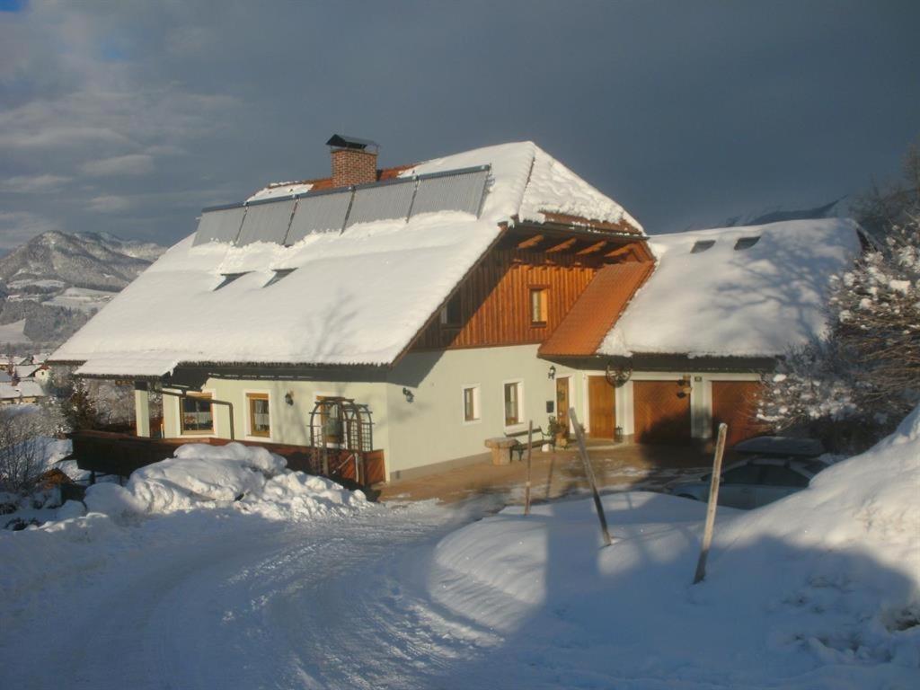 une maison recouverte de neige avec une allée couverte de neige dans l'établissement Haus Schober, à Windischgarsten