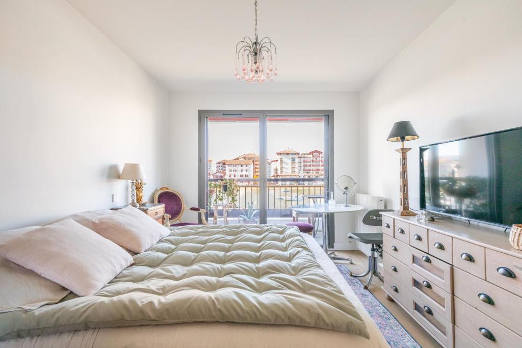 a bedroom with a large bed and a flat screen tv at Vue plongeante sur l'eau in Saint-Jean-de-Luz