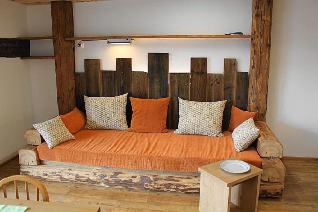 an orange bed with pillows in a room at Ponyferienhof Eder in Hengersberg