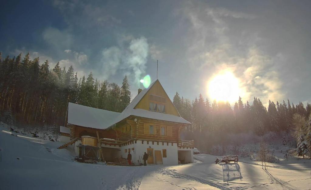 a large building in the snow with the sun behind it at Fifth Element Retreat in Borzont