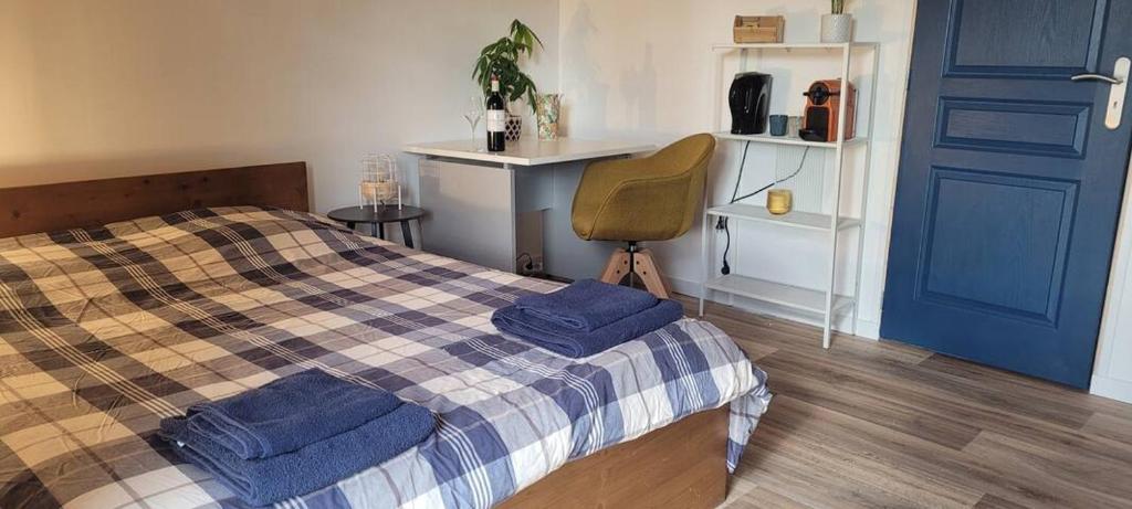 una camera da letto con un letto con asciugamani blu di Chambre indépendante chez l'habitant à la campagne proche bordeaux et l'ange bleu a Gauriaguet
