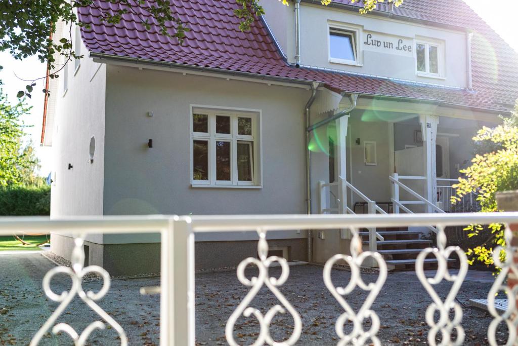 una casa con una valla delante de ella en Ferienhaus Luv und Meer en Warnemünde