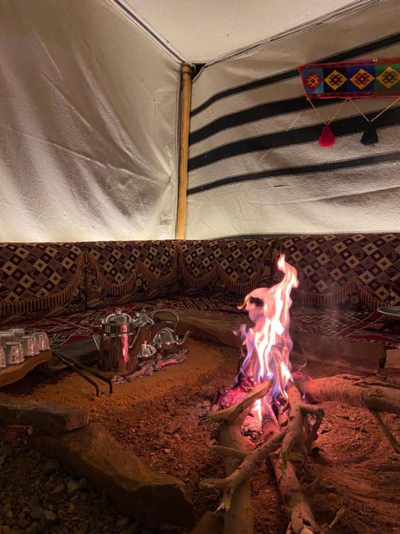 a couch with a fire in front of it at Mountain house in Al-ʿUla