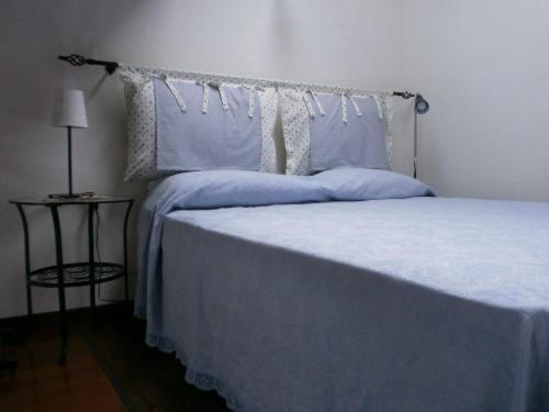 a bedroom with a bed with blue sheets and pillows at Dimora Giosafatti in Ascoli Piceno