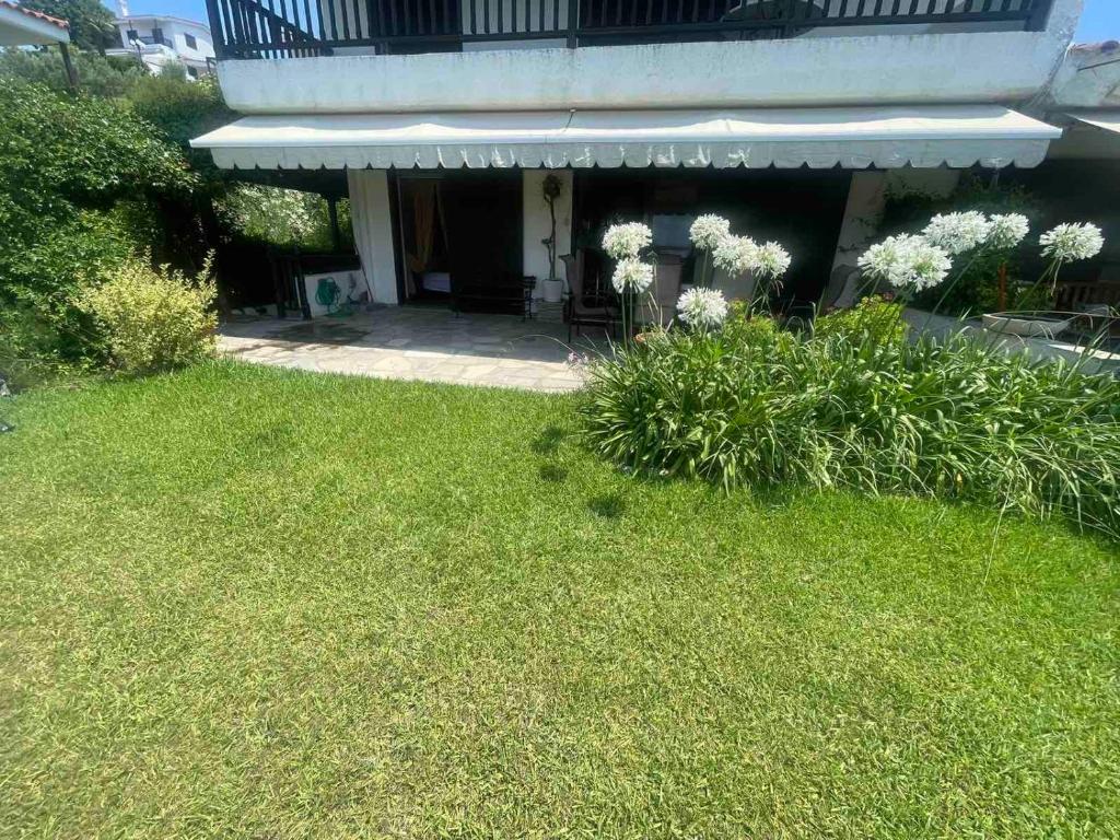 uma casa com um quintal com relva verde e flores em Elani Sea View em Elani