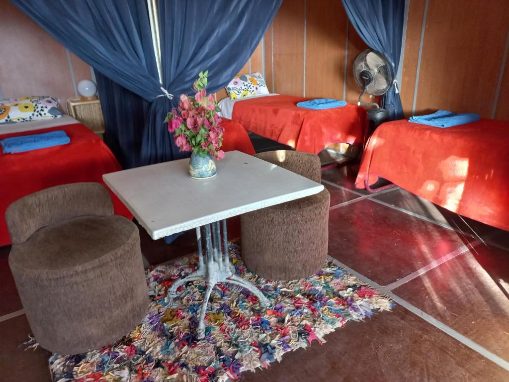 um quarto com duas camas e uma mesa e cadeiras em Auberge Village Paradise Valley em Tagherat Anekrim