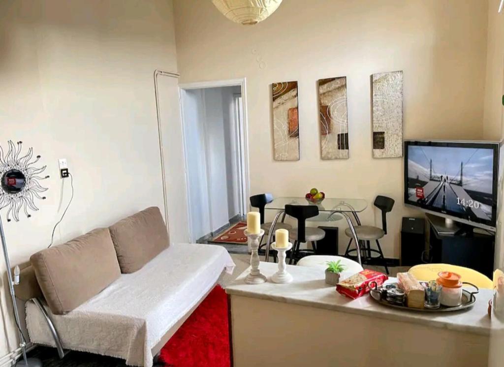 uma sala de estar com um sofá e uma televisão de ecrã plano em Nest next to the center em Mitilene