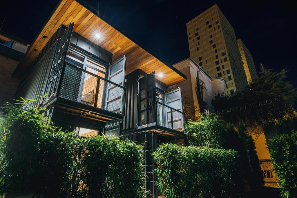 een gebouw met bomen ervoor in de nacht bij City Glamping by ONE66 Hotel in Ljubljana